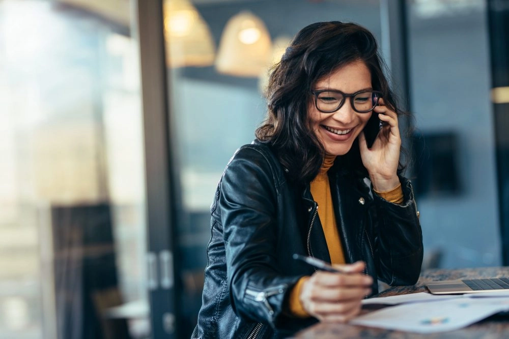 Femme entrepreneur au téléphone gère son business